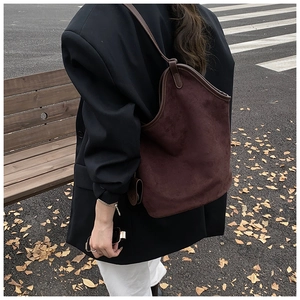 Detail of a large dark brown suede tote bag showing soft texture and premium leather trim