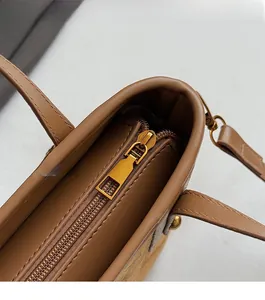 Détail de la fermeture éclair dorée et du cuir marron sur le sac seau élégant