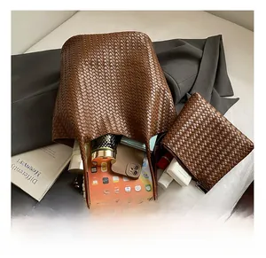 Interior capacity detail showing woven brown leather tote bag with tablet and daily essentials