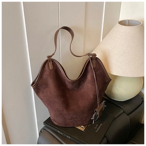 Detailed view of dark brown suede tote bag with leather trim and matching shoulder strap