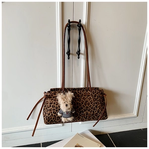 Detalle de bolso de hombro con estampado de leopardo, oso de peluche y asa marrón