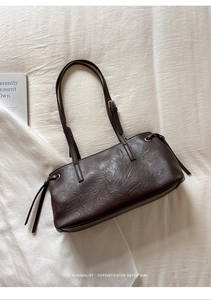 Close-up of dark brown leather texture and adjustable strap on a retro shoulder bag