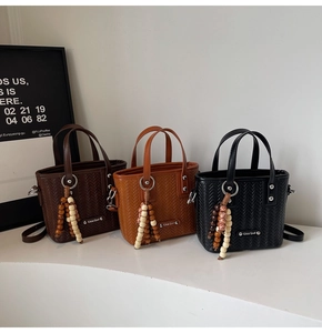 Détail de sacs à main tissés avec breloques en perles de bois en marron et noir
