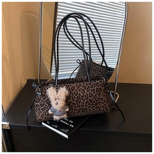 Detalle de bolso de hombro con estampado de leopardo y colgante de perro de peluche
