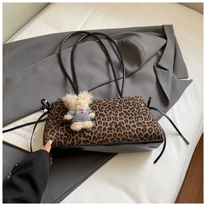 Detalle de bolso de hombro con estampado de leopardo y un colgante de oso de peluche
