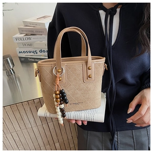 Détail du sac seau en daim matelassé avec perles en bois colorées et clous métalliques