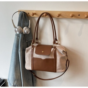 Detail der Boston Bag aus Wildleder und Leder mit Goldverschluss am Holzhaken