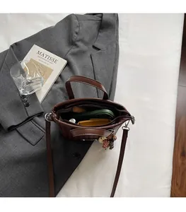 Vue de dessus d'un sac marron montrant l'intérieur spacieux avec téléphone et accessoires