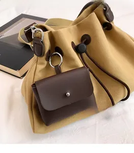 Dettaglio della borsa a secchiello in tela kaki con coulisse in pelle marrone e mini borsa