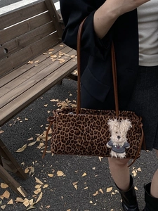 Bolso de hombro leopardo grande con colgante de perro sobre fondo de otoño vintage
