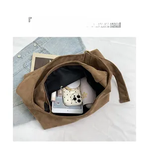 Detail view of large brown suede tote bag showing organized interior compartments