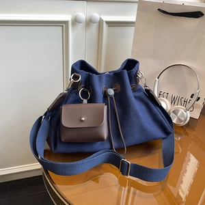 Dettaglio della borsa a secchiello in tela blu navy con coulisse e mini pochette in pelle