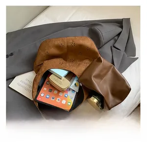 Detail of laser-cut flower patterns on brown suede tote with large capacity storage