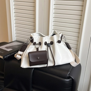 Dettaglio della borsa tote in tela con coulisse in pelle e mini pochette esterna in pelle