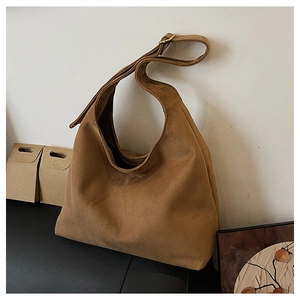 Close-up of caramel suede hobo bag with adjustable strap and gold metal hardware detail