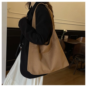 Detailed view of a brown suede large tote bag styled with a minimalist outfit in a cafe