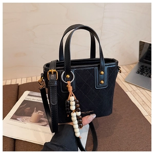 Détails du sac seau noir rétro en daim avec motif matelassé et lettrage doré chic