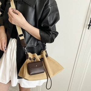 Dettaglio borsa a secchiello in tela con chiusura a coulisse e mini pochette in pelle