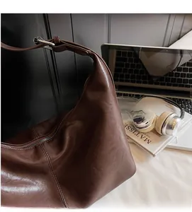 Detail of soft dark brown leather tote bag with silver hardware in a lifestyle setup
