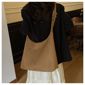 Detail of adjustable metal buckle on large brown suede hobo bag with soft matte texture