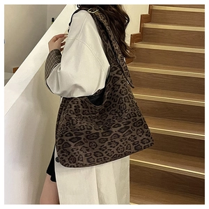 Detail of large leopard print suede tote bag showing the textured fabric and strap