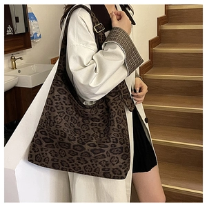 Detail shot of large leopard print suede tote bag with wide strap and gold metal buckle