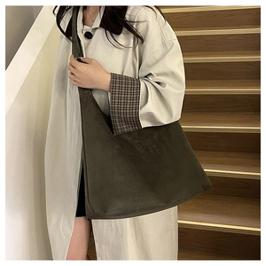 Detail of minimalist dark brown suede tote bag on wooden stairs with autumn vibe