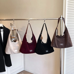 Détail de quatre sacs en daim mat avec breloques perlées ethniques et écussons logo