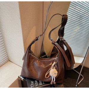 Détail de la texture cuir huilé marron foncé avec charm peluche œil rigolo