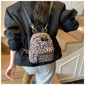 Close-up of leopard print backpack with gold metal zippers and black leather straps
