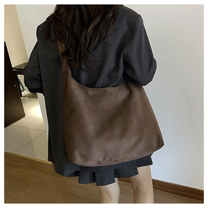 Deep brown oversized suede hobo bag shown on shoulder for silhouette and scale