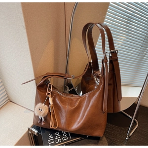 Grand sac hobo en cuir marron avec bandoulière réglable et breloque pelucheuse