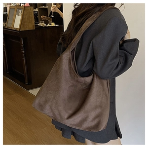 Brown suede tote bag shown on model in a cafe setting for daily commute styling