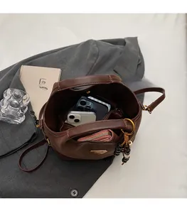 Dettaglio dell'interno di una borsa a secchiello in camoscio marrone con ampia capienza
