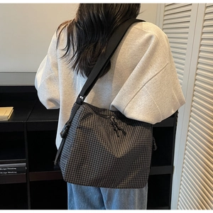 Detail of black checkered canvas tote bag with adjustable shoulder strap for women