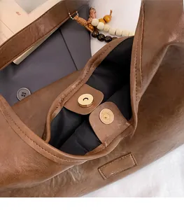 Détail du sac vintage marron avec fermeture magnétique dorée et texture cuir huilé