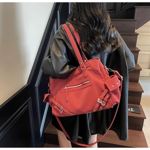 Detail view of a large matte red Boston bag with multi-pocket design and silver hardware