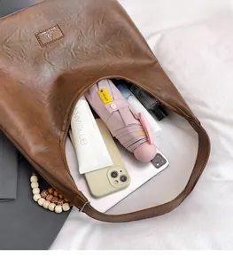 Vue intérieure montrant la grande capacité pour tablette et mobile du sac marron