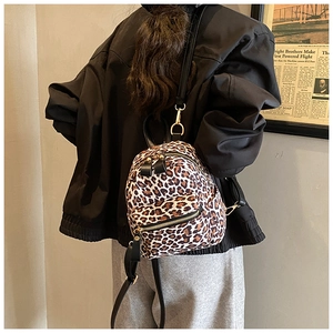 Detail view of a vintage leopard print mini backpack with golden zippers and black straps