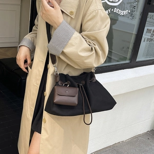 Dettaglio della borsa a secchiello in tela nera con astuccio in pelle e coulisse