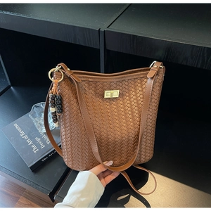 Detailansicht braune geflochtene Beuteltasche mit goldenem Drehverschluss und Holzperlen