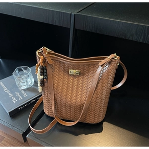 Detail der gewebten Beuteltasche mit Goldschloss und Ethno-Perlenanhänger im Regal