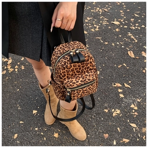 Detail of trendy leopard print mini backpack with leather handle and metal zipper detail