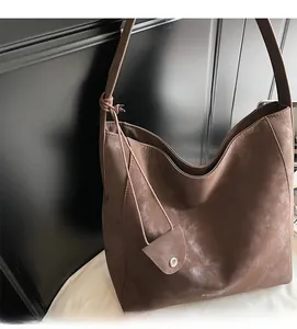 Detail of dark brown matte suede tote bag with stylish knot strap and metal buckle charm
