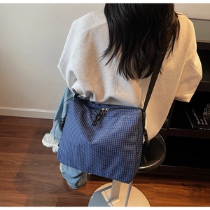 Detailed back view of a blue checkered tote bag showing adjustable strap and large capacity