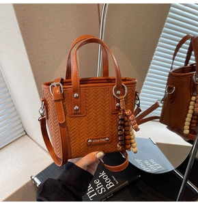 Détail du sac seau marron en similicuir tressé avec perles en bois et rivets argentés