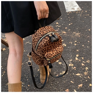 Detail of leopard print mini backpack with gold zippers and black fabric straps