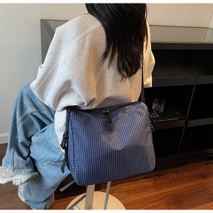 Detail of navy blue plaid canvas tote bag with adjustable shoulder strap and large capacity