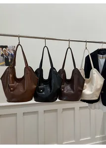 Detail of four retro leather tote bags in brown black coffee and cream colors