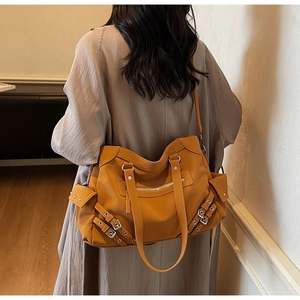 Detail of vintage matte mustard yellow tote bag with metal buckles and side pockets